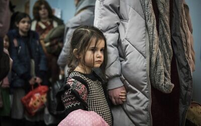 Children and their companions from an orphanage in Odesa, Ukraine, wait for room allocation after their arrival at a hotel in Berlin, on Friday, March 4, 2022. More than 100 Jewish refugee children who were evacuated from a foster care home in war-torn Ukraine and made their way across Europe by bus have arrived in Berlin. (AP Photo/Steffi Loos)