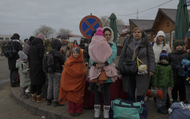Refugees, mostly women with children, wait for transportation at the border crossing in Medyka, Poland, on March 5, 2022, after fleeing from Ukraine. (AP Photo/Markus Schreiber)
