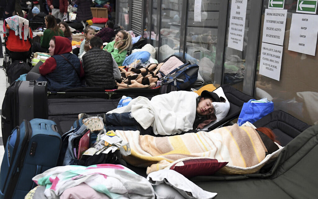 People rest at a reception center for people displaced from Ukraine at the Ukrainian-Polish border crossing in Korczowa, Poland, March 5, 2022. (Olivier Douliery, Pool Photo via AP)