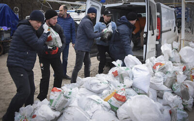 Volunteers load sandbags into the back of a bus to build barricades in Odesa, Ukraine, March 5, 2022.   (AP Photo/Max Pshybyshevsky)