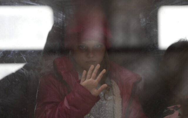 A young girl fleeing the war in Ukraine looks out of the window as she arrives at the train station in Przemysl, Poland, March 6, 2022. (AP Photo/Markus Schreiber)