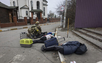 Ukrainian servicemen try to help people wounded, in the town of Irpin, Ukraine, March 6, 2022. (Andriy Dubchak/AP)