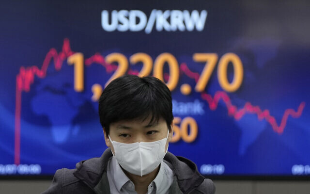 A currency trader walks near the screen showing the foreign exchange rate between US dollar and South Korean won at a foreign exchange dealing room in Seoul, South Korea,  March 7, 2022  (AP Photo/Lee Jin-man)