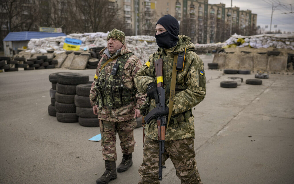A Ukrainian serviceman has "Mommy" written on his weapon strap as he stands guard at a checkpoint on a main road in Kyiv, Ukraine, Monday, March 7, 2022. (AP/Vadim Ghirda)