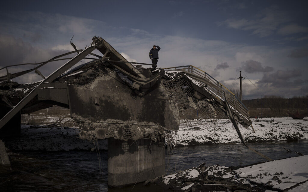 A man stands atop a destroyed bridge in Irpin, on the outskirts of Kyiv, Ukraine,  March 8, 2022. (AP Photo/Felipe Dana)