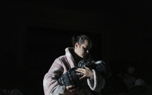 A woman holds a baby in a bomb shelter in Mariupol, Ukraine, March 8, 2022. (AP Photo/Evgeniy Maloletka)