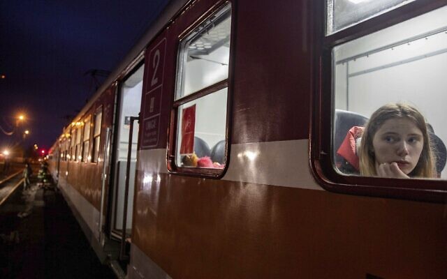 A young woman looks out from a train heading to Krakow, after fleeing Ukraine, at the train station at border crossing in Medyka, Poland, March 8, 2022 (AP Photo/Visar Kryeziu)