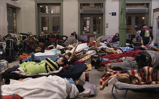 Refugees sleep at night at the train station in Przemysl, Poland, March 2, 2022. (AP Photo/Marc Sanye)