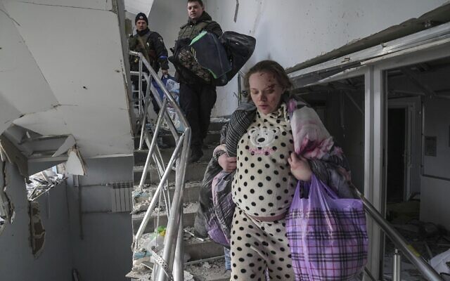 A pregnant woman walks downstairs at the Russia-bombarded maternity hospital in Mariupol, Ukraine, Wednesday, March 9, 2022. (AP Photo/Evgeniy Maloletka)
