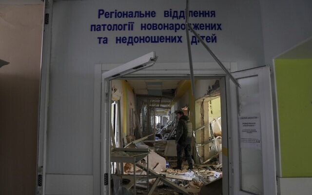 A volunteer works inside of the damaged by shelling maternity hospital in Mariupol, Ukraine, Wednesday, March 9, 2022. (AP Photo/Evgeniy Maloletka)