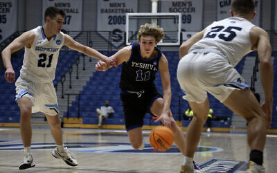 Yeshiva University's Ryan Turell (11) dribbles the ball down court while being defended by Johns Hopkins University's Carson James (21) and Lincoln Yeutter (25) in the first round of the NCAA's Division III basketball tournament, in Galloway Township, N.J., on Friday, March 4, 2022. The Yeshiva Maccabees lost to the Blue Jays, 63-59 at Stockton University Sports Center. (AP Photo/Jessie Wardarski)