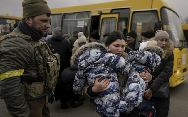 A woman who was evacuated areas around the Ukrainian capital, carries two babies after arriving at a triage point in Kyiv, Ukraine, Wednesday, March 9, 2022. A Russian airstrike devastated a maternity hospital Wednesday in the besieged port city of Mariupol amid growing warnings from the West that Moscow’s invasion is about to take a more brutal and indiscriminate turn. (AP Photo/Vadim Ghirda)