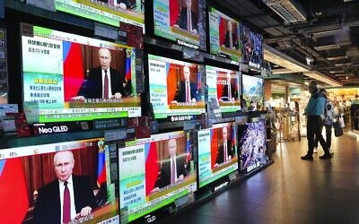 People stand by TV screens broadcasting the news of Russian troops that have launched their attack on Ukraine, in Hong Kong Thursday, Feb. 24, 2022. (AP/Vincent Yu)