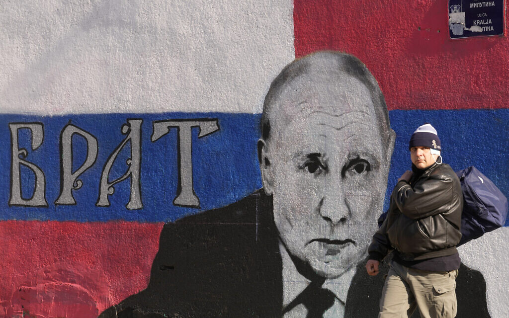 A man passes by a mural depicting the Russian President Vladimir Putin, that reads: ''Brother'' in Belgrade, Serbia, March 12, 2022. (AP Photo/Darko Vojinovic)