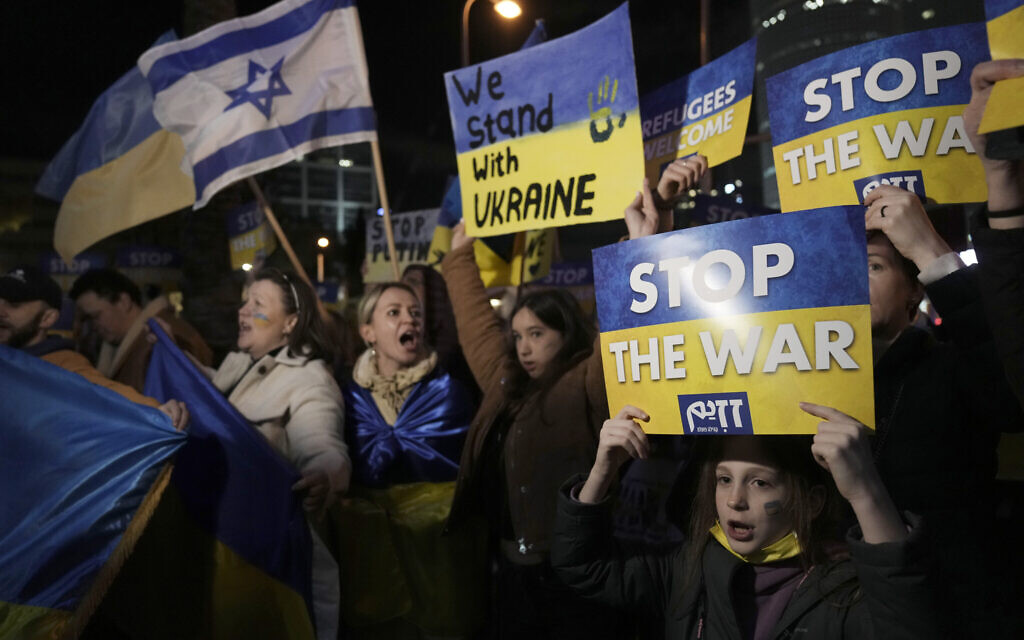 People hold placards as they take part in a protest against the Russian invasion of Ukraine, outside government office in Tel Aviv, March 12, 2022. (AP/Ariel Schalit)