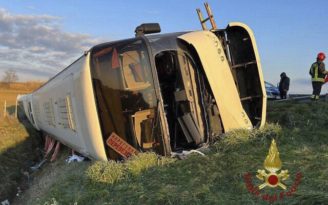 A bus lies on its side after overturning near Forli, Italy, Sunday, March 13, 2022 (Vigili del Fuoco via AP)