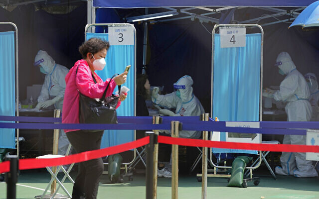 Medical workers help residents to get tested for the coronavirus at a temporary testing center in Hong Kong, March 14, 2022. (AP Photo/Kin Cheung)
