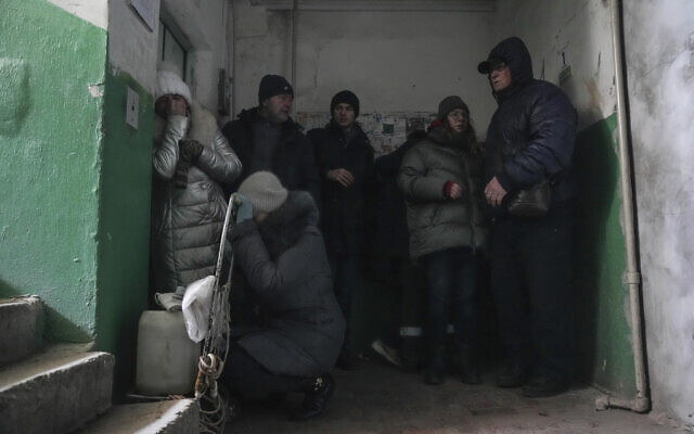 People cover from shelling inside an entryway to an apartment building in Mariupol, Ukraine, March 13, 2022. (Evgeniy Maloletka/AP)