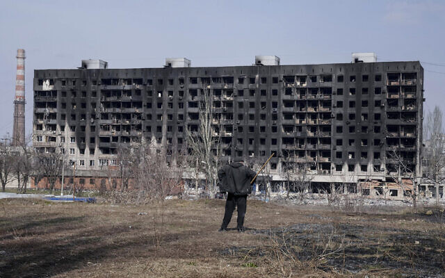 A man looks at a burned apartment building that was damaged by shelling in Mariupol, Ukraine, on Sunday, March 13, 2022. (AP/Evgeniy Maloletka)