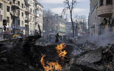 Firefighters extinguish flames outside an apartment house after a Russian rocket attack in Kharkiv, Ukraine's second-largest city, Ukraine, March 14, 2022. (AP Photo/Pavel Dorogoy)