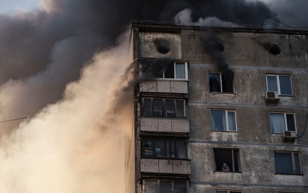 An elderly resident waits to be rescued by Ukrainian firefighters after bombing in an apartment building in Kyiv, Ukraine, Tuesday, March 15, 2022. (AP Photo/Felipe Dana)