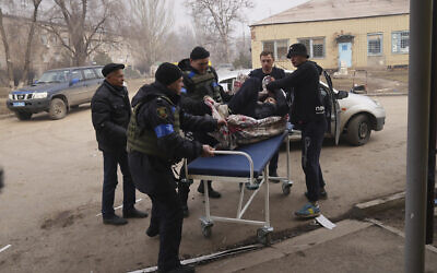 Ukrainian servicemen and volunteers carry a man injured during a shelling attack into hospital number 3 in Mariupol, Ukraine, Tuesday, March 15, 2022. (AP/Evgeniy Maloletka)