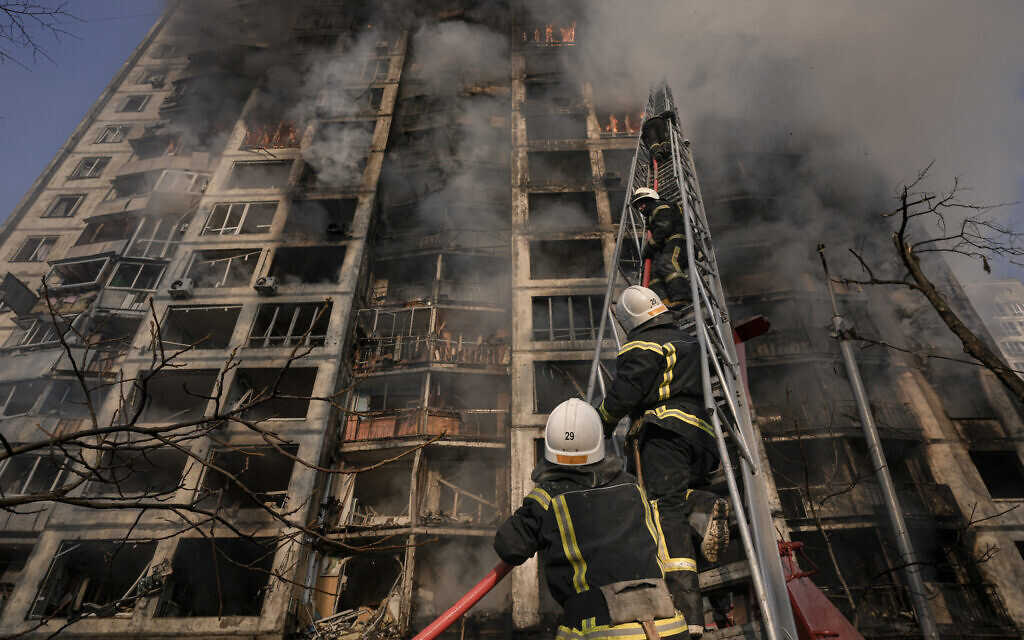 Firefighters climb a ladder while working to extinguish a blaze in a destroyed apartment building after a bombing in a residential area in Kyiv, Ukraine, on Tuesday, March 15, 2022. (AP/Vadim Ghirda)
