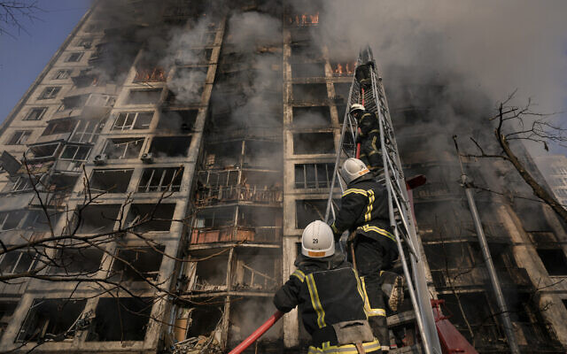Firefighters climb a ladder while working to extinguish a blaze in a destroyed apartment building after a bombing in a residential area in Kyiv, Ukraine, on Tuesday, March 15, 2022. (AP/Vadim Ghirda)