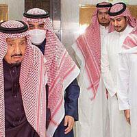 In this photo released by Saudi Press Agency, Saudi King Faisal walks with a cane as he leaves King Faisal Specialist Hospital with Saudi Crown Prince Mohammed bin Salman, right, and entourage, in Riyadh, Saudi Arabia, March, 16, 2022. (Saudi Press Agency via AP)