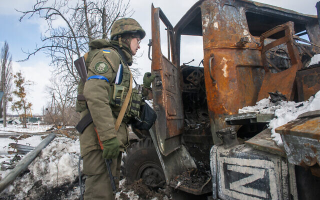 A Ukrainian national guard soldier inspects a damaged Russian military vehicle in Kharkiv, Ukraine, March 16, 2022. (AP Photo/Andrew Marienko)