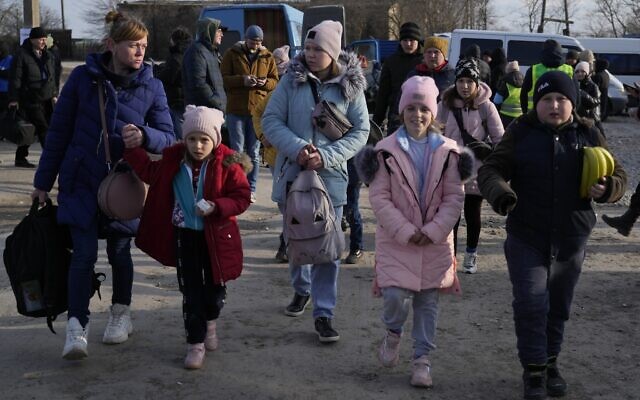 Refugees leaving to Romania after fleeing from Ukraine, walk at the border crossing in Palanca, Moldova, March 17, 2022. (AP Photo/Sergei Grits)