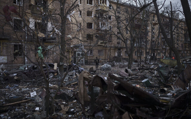 A police officer walks at the site of a bombing that damaged residential buildings in Kyiv, Ukraine, on March 18, 2022. (AP Photo/Felipe Dana)