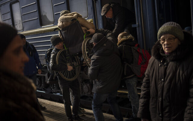Ukrainians escaping from the besieged city of Mariupol along with other passengers from Zaporizhzhia arrive at Lviv, western Ukraine, on Sunday, March 20, 2022. (AP Photo/Bernat Armangue)