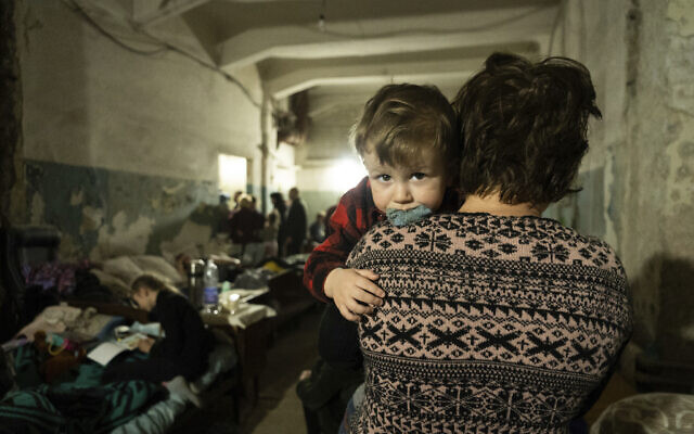 A woman holds a child in an improvised bomb shelter in Mariupol, Ukraine, March 7, 2022. (AP Photo/Mstyslav Chernov)