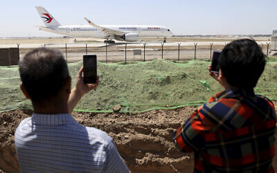 Illustrative: Residents watch as a China Eastern passenger jet prepares to take off on a test flight from the new Beijing Daxing International Airport on May 13, 2019. (Ng Han Guan/AP)