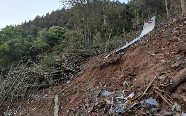 In this photo taken by mobile phone released by Xinhua News Agency, a piece of wreckage of the China Eastern's flight MU5735 is seen after it crashed on the mountain in Tengxian County, south China's Guangxi Zhuang Autonomous Region on March 21, 2022. (Xinhua via AP)