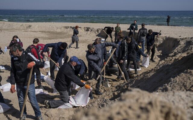 Volunteers at a sand beach fill sandbags to defend their city, in Odesa, southern Ukraine, March 23, 2022. (Petros Giannakouris/AP)