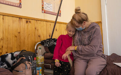 Natalia Moiseinko holds her 10-year-old daughter Zlata Moiseinko, suffering from a chronic heart condition, as she receives treatment at a schoolhouse that has been converted into an Israeli field hospital in Mostyska, western Ukraine, on March 24, 2022. (AP Photo/Nariman El-Mofty)