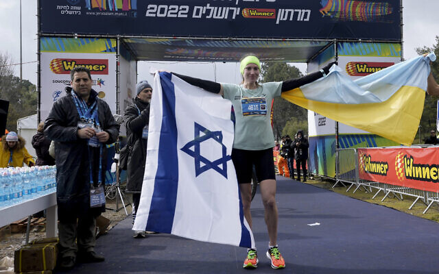Ukrainian runner Valentyna Veretska poses with the Ukrainian and Israeli flags after finishing first among women in the Jerusalem marathon, March 25, 2022. (AP Photo/Mahmoud Illean)