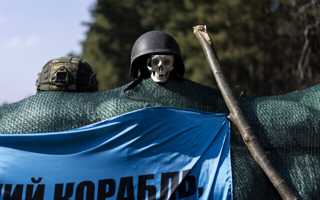 A plastic skull is displayed at a check point on the outskirts of Kyiv, Ukraine, Friday, March 25, 2022. (AP Photo/Rodrigo Abd)