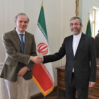 Enrique Mora, a leading European Union diplomat, left, shakes hands with Iran's top nuclear negotiator Ali Bagheri Kani in Tehran, Iran, March 27, 2022. (Iranian Foreign Ministry via AP)