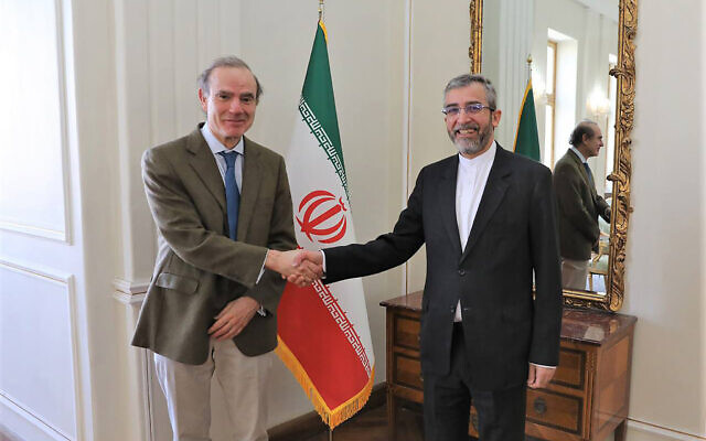 Enrique Mora, a leading European Union diplomat, left, shakes hands with Iran's top nuclear negotiator Ali Bagheri Kani in Tehran, Iran, March 27, 2022. (Iranian Foreign Ministry via AP)