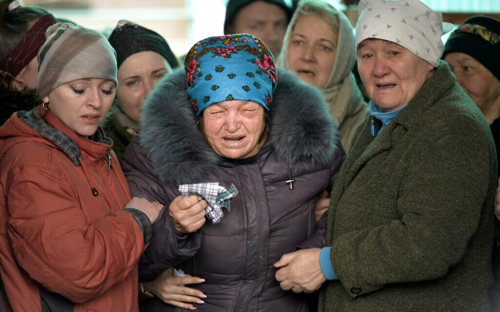 The mother of Russian Army soldier Rustam Zarifulin, who was killed fighting in Ukraine, center, cries surrounded by relatives during a farewell ceremony in his homeland in Kara-Balta, 60 km (37 miles) west of Bishkek, Kyrgyzstan, March 27, 2022. (AP Photo/Vladimir Voronin)