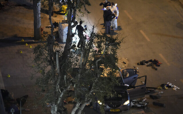 Police inspect the scene of a shooting attack In Hadera, March 27, 2022. (AP Photo/Ariel Schalit)