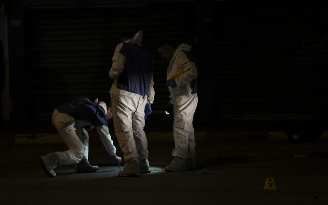 Israeli police inspect the scene of a shooting attack in Hadera, Israel, Sunday, March 27, 2022. (AP Photo/Ariel Schalit)
