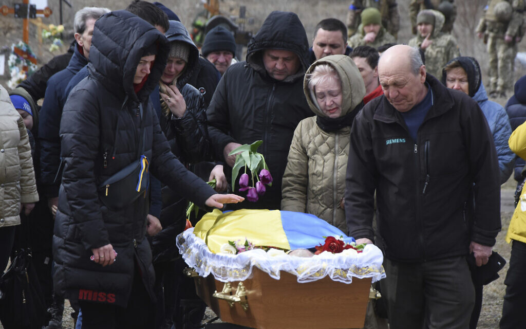 Relatives and friends react near the coffin of Ukrainian servicemen Oleksiy Lunyov in Yuzhne, Odessa region, Ukraine, March 27, 2022 (AP Photo/Max Pshybyshevsky)