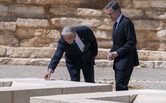 After meeting for the Negev Summit, Foreign Minister Yair Lapid, and US Secretary of State Antony Blinken place stones as a sign of respect on the grave of David Ben Gurion, while visiting David Ben Gurion National Park, March 28, 2022, in Sde Boker, southern Israel. (AP Photo/Jacquelyn Martin, Pool)