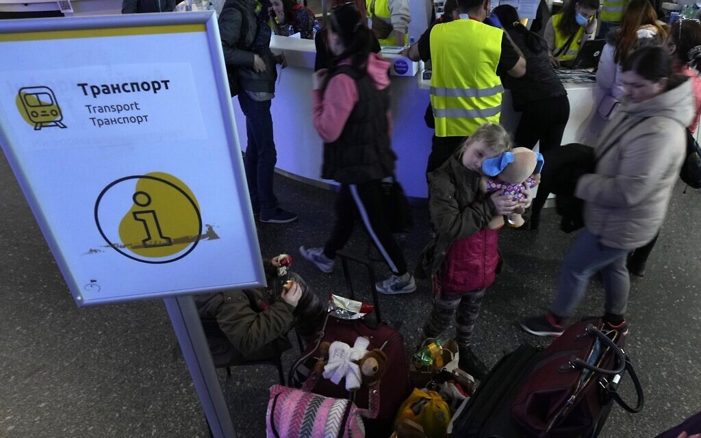 A girl holds her toy as Ukrainian refugees take directions at the central train station in Warsaw, Poland, March 28, 2022. (AP Photo/Czarek Sokolowski)