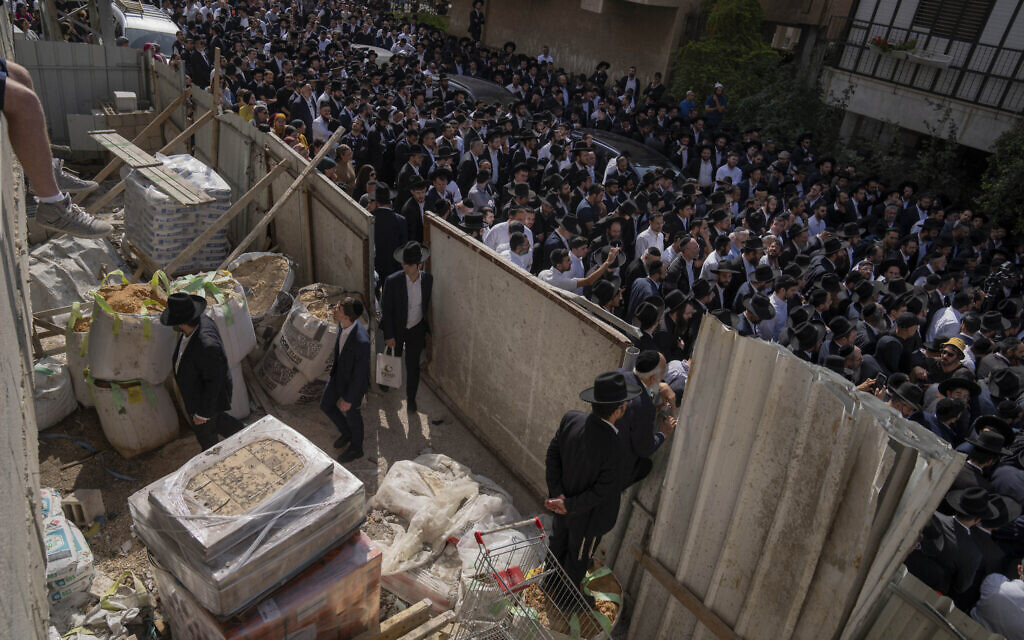 Mourners gather around the body of Avishai Yehezkel, 29, during his funeral in Bnei Brak, March 30, 2022 (AP Photo/Oded Balilty)