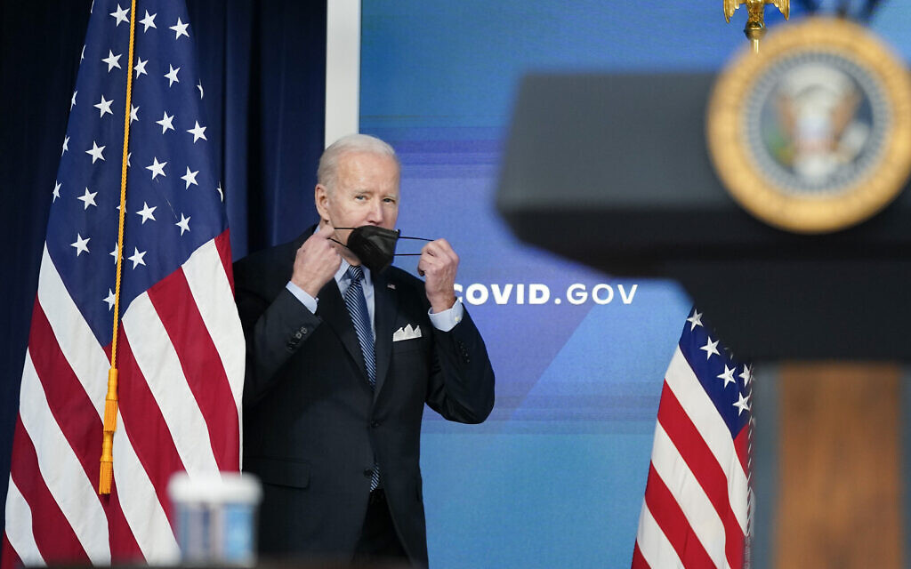 President Joe Biden holds his facemask as he arrives to speak about status of the country's fight against COVID-19 in the South Court Auditorium on the White House campus, Wednesday, March 30, 2022, in Washington. (AP/Patrick Semansky)